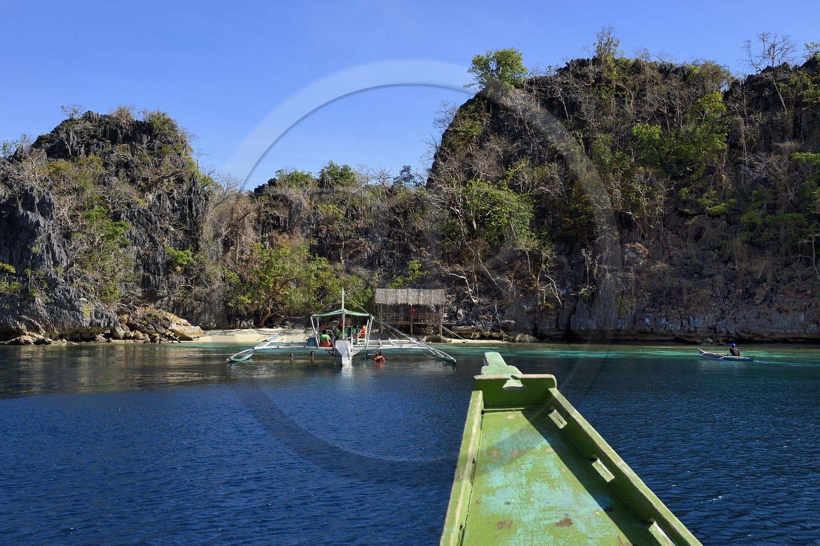 Philippines, Calamian Islands dans le nord de Palawan, Coron Island Natural Biotic Area, pirogue à balancier au pied des rochers de calcaire dans une petite crique