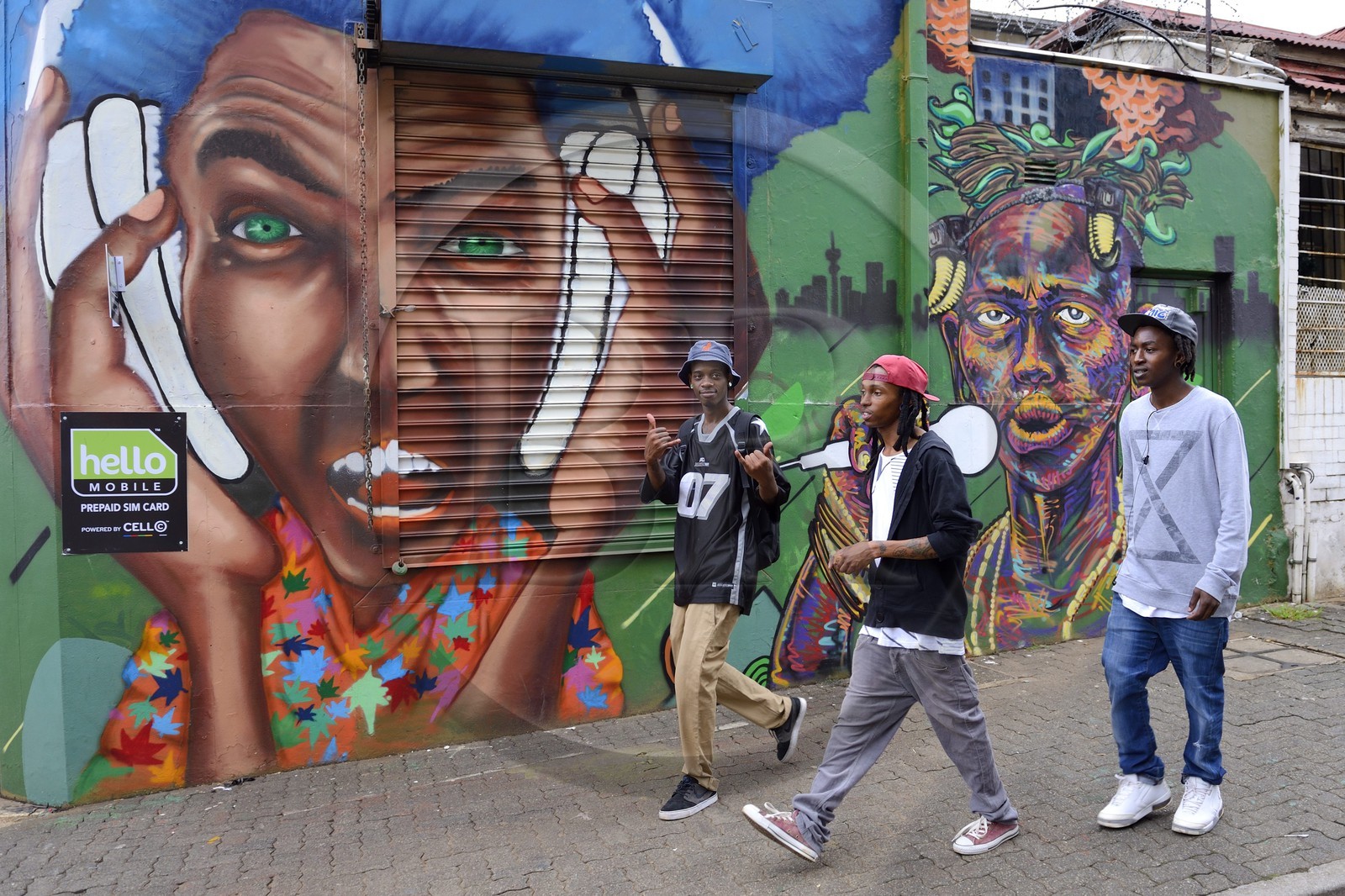 Afrique du Sud, province de Gauteng, Johannesburg, quartier de Braamfontein, groupe de jeunes devant un mur peint dans De Korte street