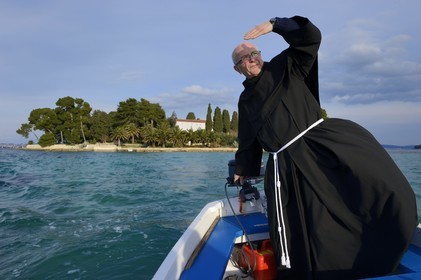 Croatie, Dalmatie, côte dalmate, Ile d’Ugljan, Preko, le frère franciscain Bozo Susic quittant le Monastère Franciscain de l'îlot Galovac sur sa barque