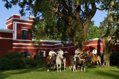 Argentine, province de Buenos Aires, San Antonio de Areco, groupe de gauchos à cheval devant l'estancia La Bamba de Areco