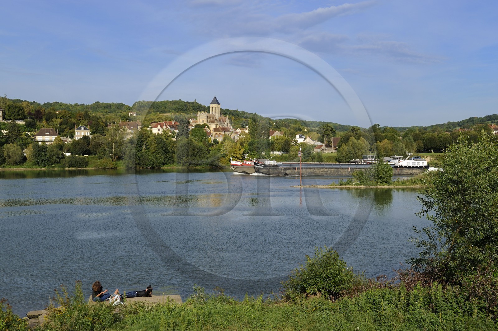 France, Val-d'Oise (95), une péniche descent la Seine devant le village de Vétheuil et son église Notre Dame peinte par Claude Monet