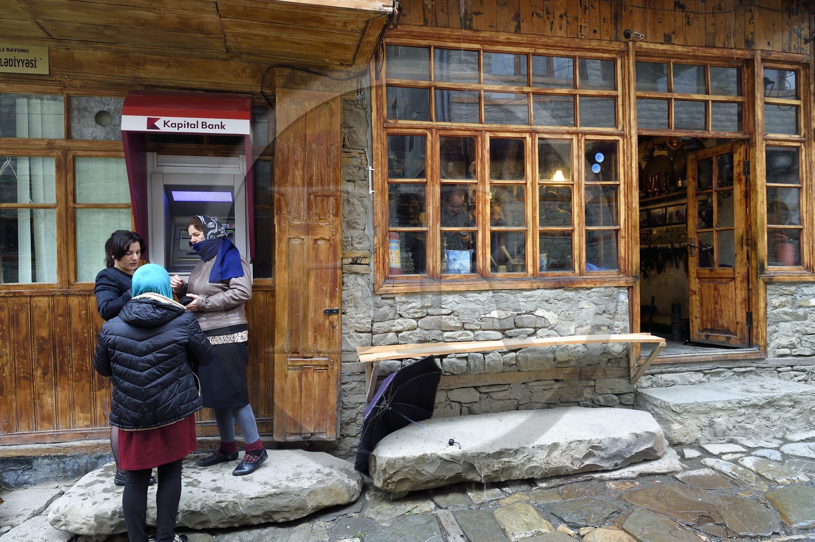 Azerbaïdjan, région de Ismailli, la rue principale de Lahij (Lahic), femmes utilisant un distributeur de billets ou un guichet automatique