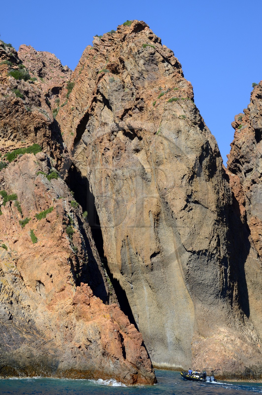 France, Corse-du-Sud (2A), Golfe de Porto, classé Patrimoine Mondial de l'UNESCO, Réserve naturelle de Scandola, petite embarcation qui entre profondément dans les failles des falaises
