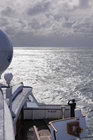 Iceland, toward Denmark Strait on board the cruise ship Princess Danae, an officer scans the horizon