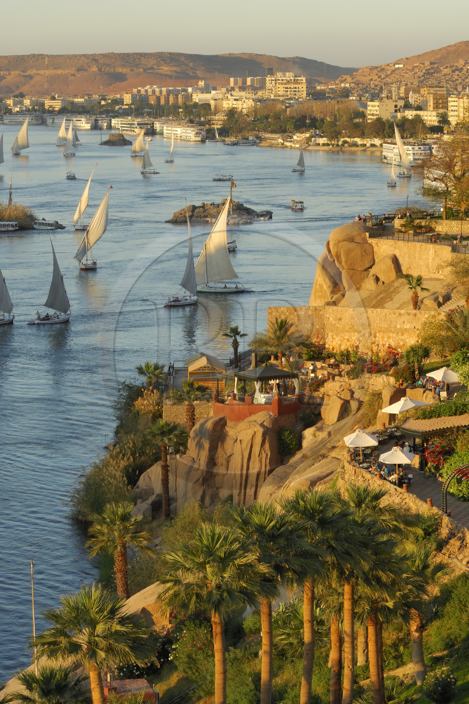 Egypte, Haute Egypte, Nubie, vallée du Nil, Assouan, felouques et bateau de croisière sur le Nil à la hauteur de l'hotel Old Cataract, le port en arrière plan