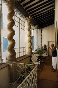 France, Hérault (34), Pézenas, Hôtel d'Alfonse du 17éme siècle rue Conti où Molière et sa troupe donnèrent «le Médecin Volant», la propriétaire madame Aubert devant les colonnes torses monolithes à chapiteaux corinthiens qui soutiennent un toit en appentis