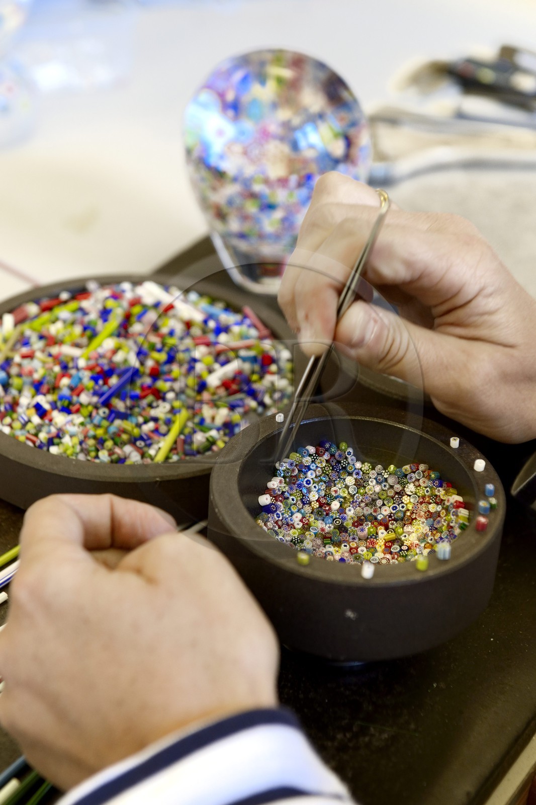 France, Moselle (57), Saint-Louis-les-Bitche, la Cristallerie Saint-Louis, préparation d'une boule presse-papiers à partir de baguettes de cristal de couleur modelés au chalumeau, aux pincettes et ciseaux