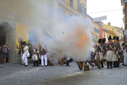 Italy, Liguria, Sarzana, Piazza Matteotti, Napoleon Festival, austrian soldiers firing the cannon at the french enemy in the main street Via Mazzini in the old town