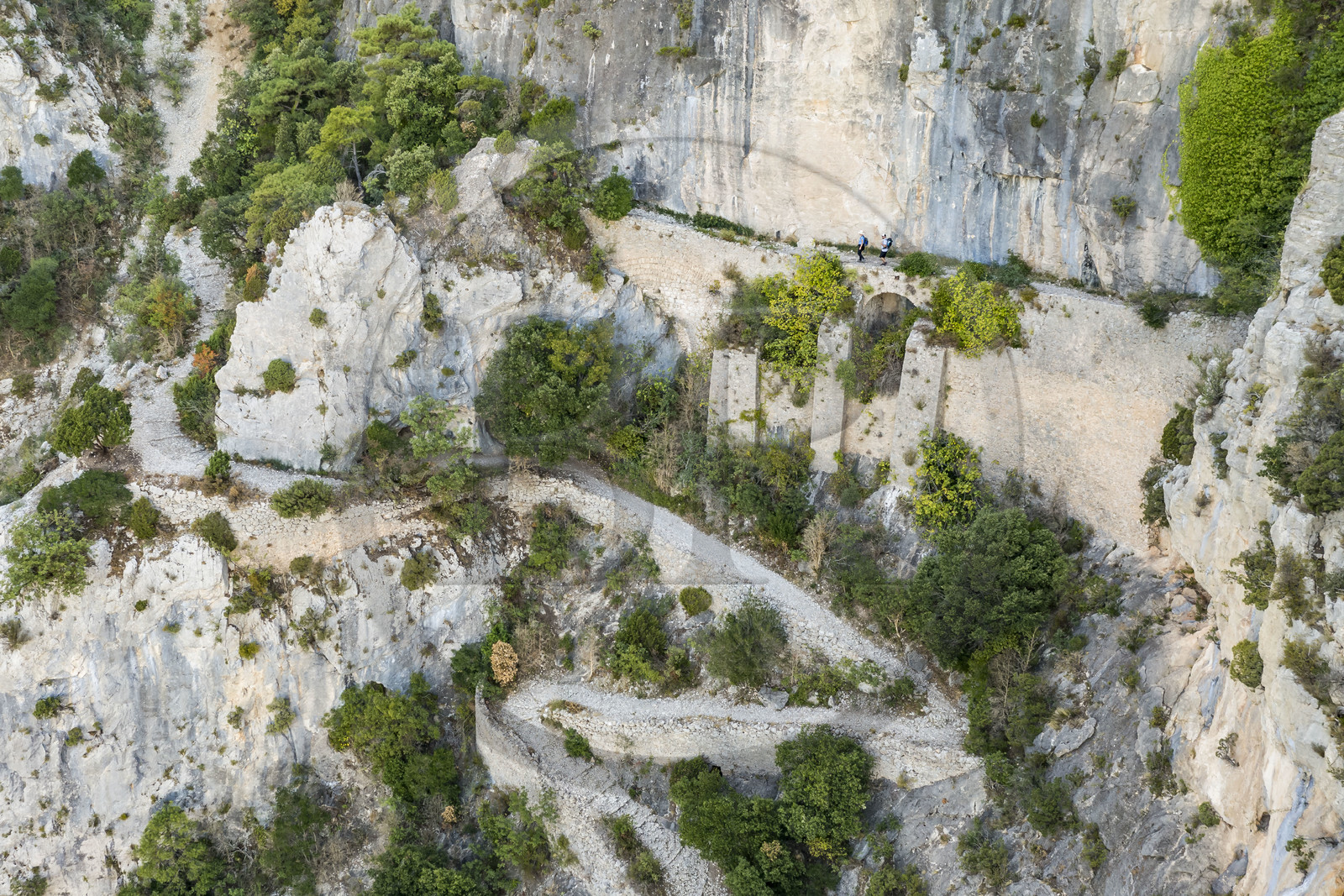 France, Hérault (34), Causses et les Cévennes, paysage culturel de l'agro-pastoralisme méditerranéen, classés Patrimoine Mondial de l'UNESCO, Saint-Guilhem-le-Désert, labellisé Les Plus Beaux Villages de France, randonneurs sur la Via Tolosana sur le Chemin de Saint-Jacques-de-Compostelle, le passage des Fenestrelles aménagé au Moyen-age par les moines de l'abbaye afin de franchir ce verrou rocheux dans le cirque de l'Infernet (vue aérienne)