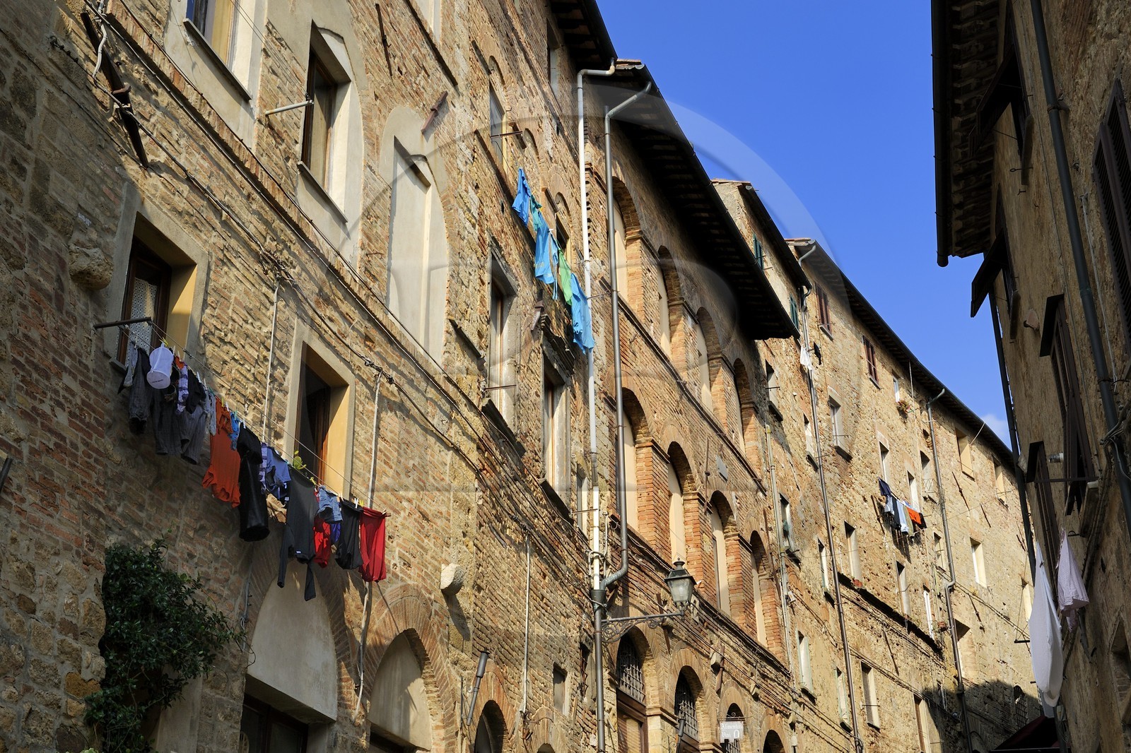 Italie, Toscane, Val di Cecina, Volterra, linge pendant aux fenetres des immeubles de la vieille ville dans la via Porta all'Arco