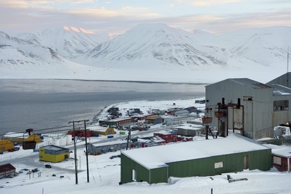 Norvège, Svalbard, Spitzberg, Longyearbyen, la zone industrielle de la ville et au premier plan le batiment central abandonné du téléphérique utilisé pour le transport des chariots de charbon des mines vers le port