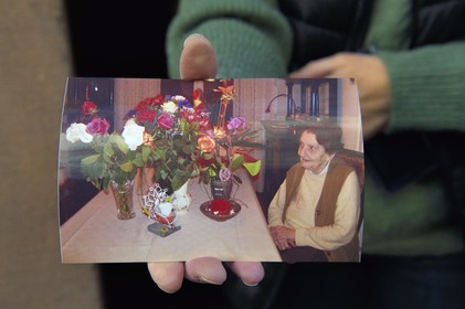 France, Bas-Rhin, Schiltigheim, Geneviève Zaehringer holds the photo of her centenarian aunt, now deceased, who owned the radium fountain, a glass of water in which porcelain irradiated with radium was infused