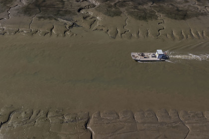 France, Charente Maritime, Oleron island, le Chateau-d'Oleron, oyster boat in the port exit channel at low tide (aerial view)