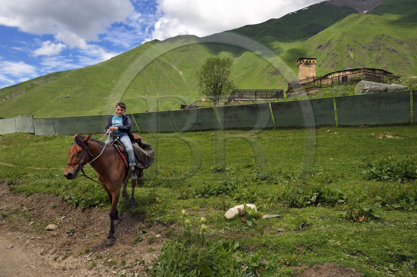 Géorgie, Haute Svanétie (Zemo Svaneti), village de Ushguli (Ouchgouli), classé Patrimoine Mondial de l'UNESCO, jeune cavalier devant l'église Lamaria Sainte-Marie d'Ushguli du XIIème siècle