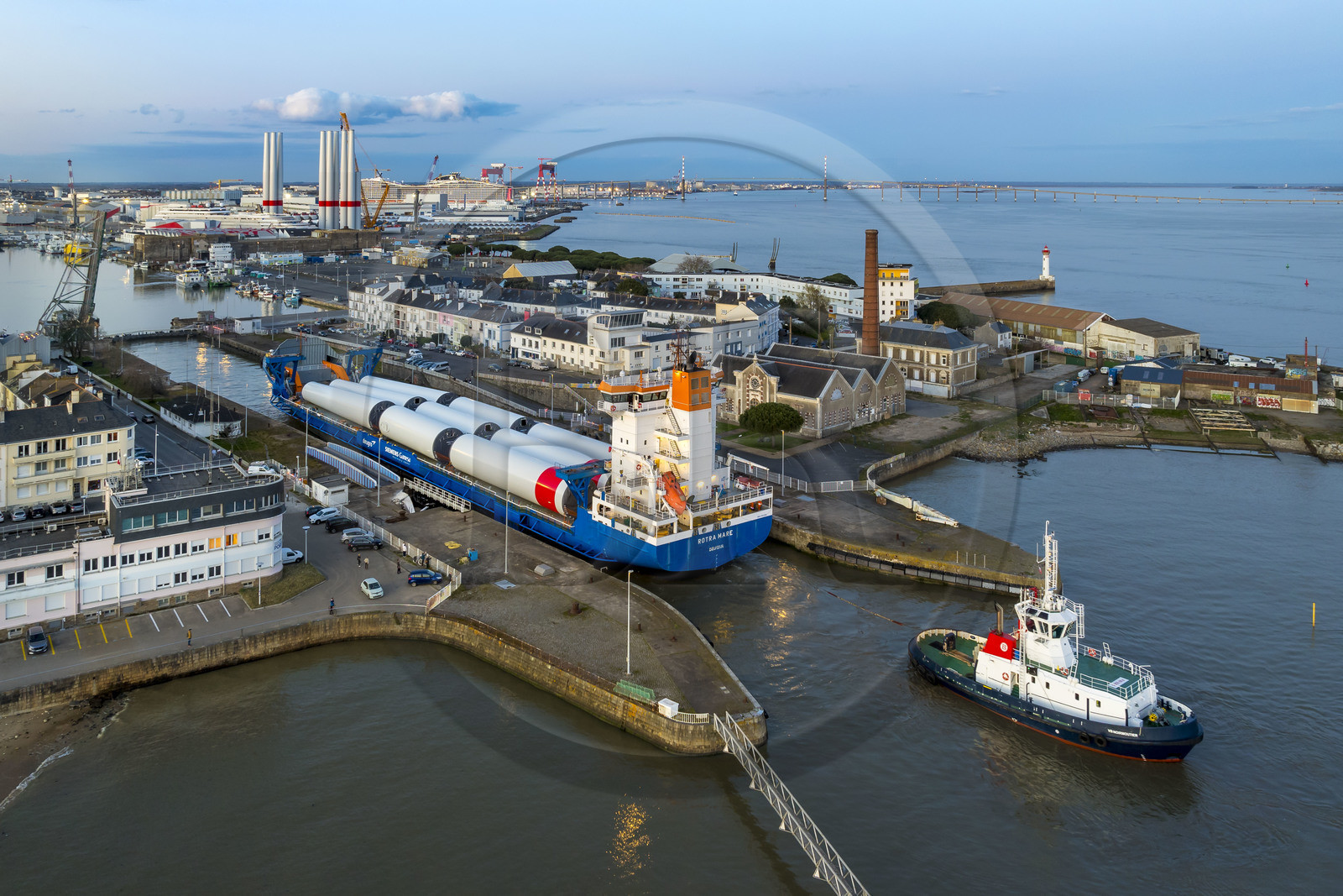 France, Loire Atlantique, Saint Nazaire, The General Cargo Rotra Mare transports sections of wind turbine masts and enters the port's wet dock (in the background) via the south lock, which was also the site of Operation Chariot launched in 1942 by the British (aerial view)