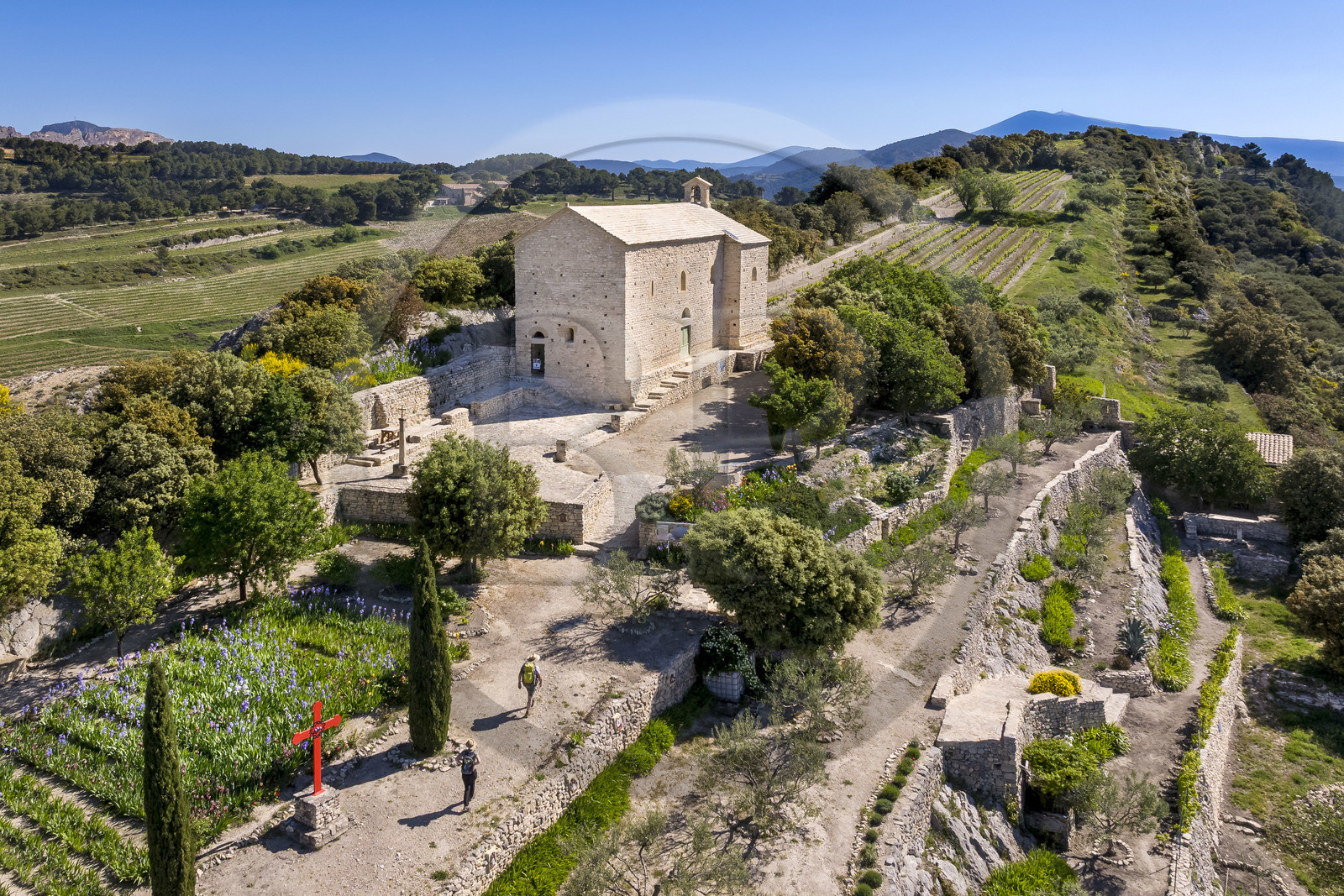 France, Vaucluse, Dentelles de Montmirail mountains, Beaumes de Venise, hikers in front of the Saint-Hilaire chapel, which dates back to the 6th century on the Courens plateau, and Mont Ventoux in the background (aerial view)