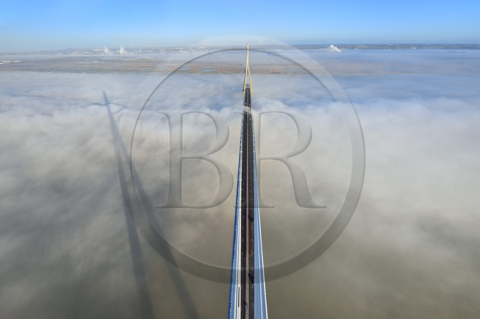 France, entre Calvados (14) et Seine-Maritime (76), le Pont de Normandie enjambe la Seine et émerge d'une mer de nuages, la Réserve Naturelle de l'estuaire de la Seine en arrière plan