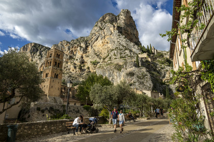 France, Alpes-de-Haute-Provence (04), Parc Naturel Régional du Verdon, Moustiers-Sainte-Marie, labellisé Les Plus Beaux Villages de France, l'église Notre-Dame-de-l'Assomption avec son clocher du XIIe siècle en tuff et la chapelle Notre-Dame de Beauvoir en arrière plan dans la falaise