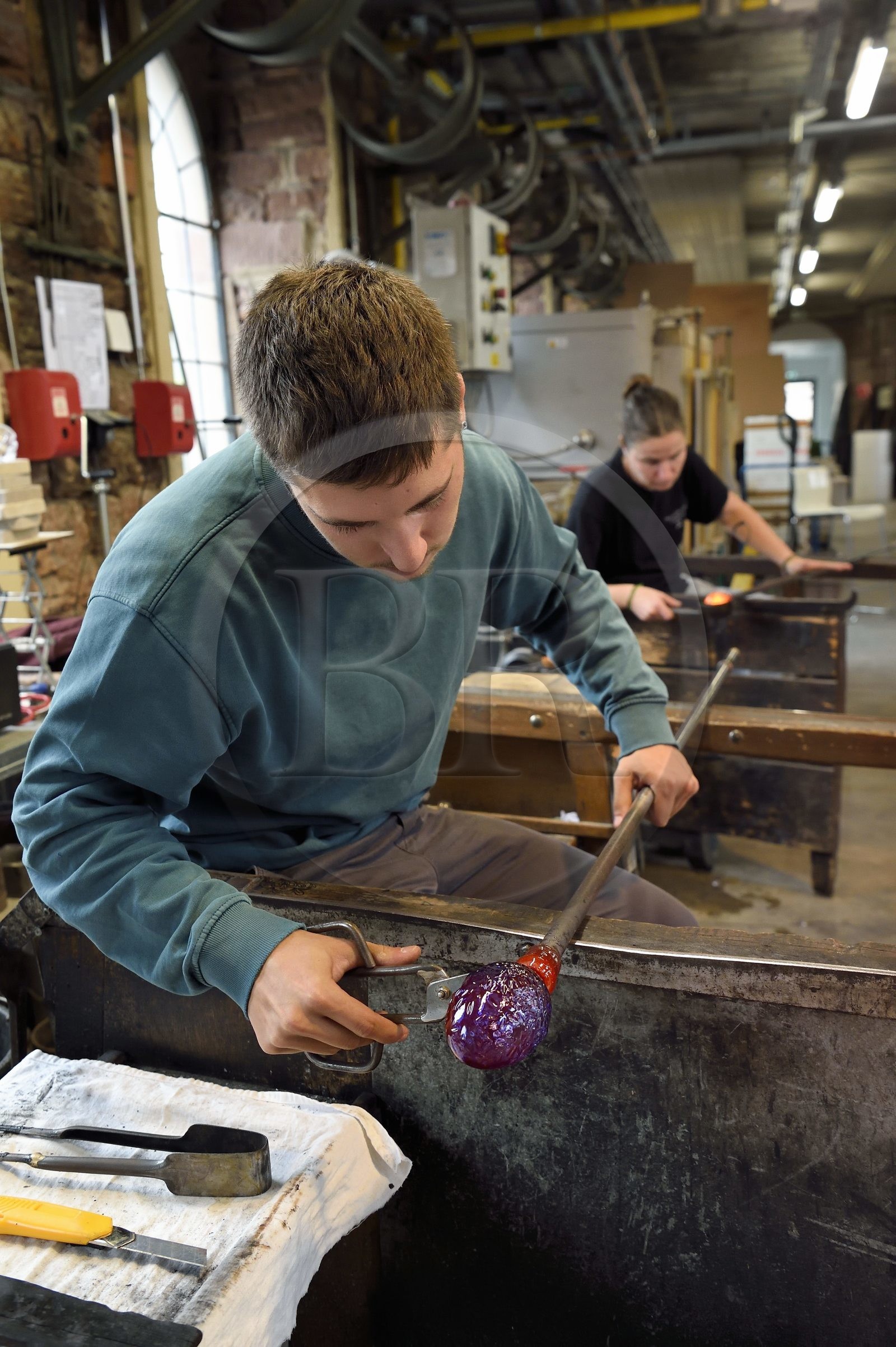 France, Moselle (57), Meisenthal, Centre international d’Art verrier (CIAV), l'atelier de soufflage, fabrication artisanale d'une boule de Noël, façonnage à la sortie du moule de soufflage