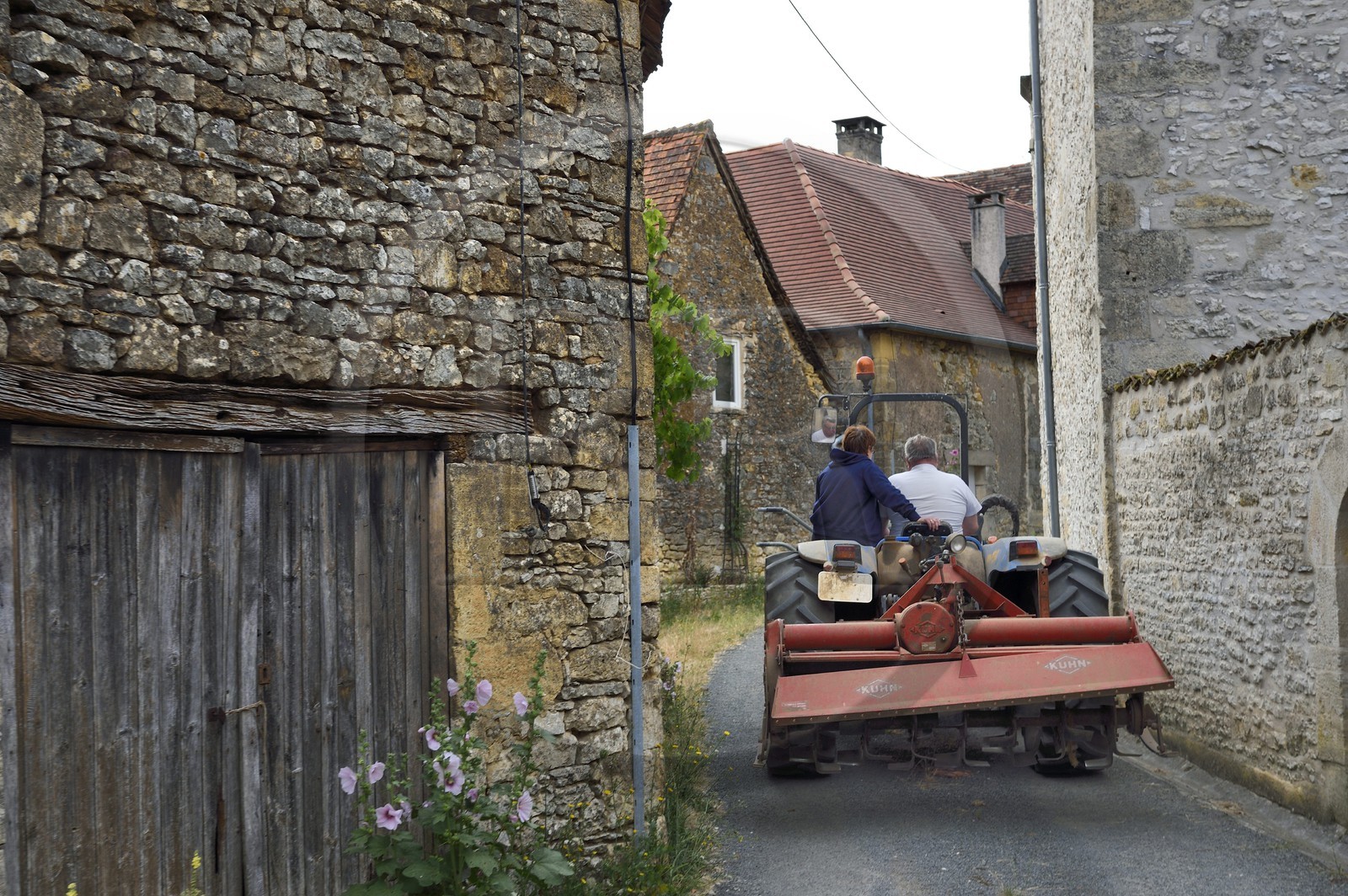 France, Dordogne (24), Périgord Noir, Saint-Rabier, Monique et Bernard Gaillard propriétaires de la Ferme-auberge du Grand Coderc sur leur tracteur