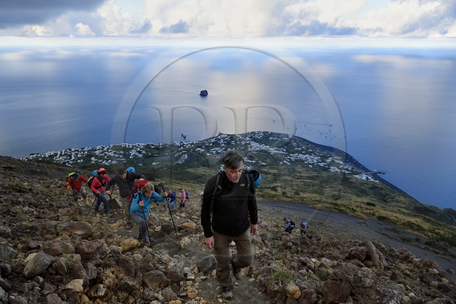 Italy, Sicily, Aeolian Islands, listed as World Heritage by UNESCO, Stromboli island, hikers climbing the volcano, the village of Stromboli and the islet of Strombolicchio in the background