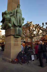 France, Bas-Rhin (67), Strasbourg, vieille ville classée Patrimoine Mondial de l'UNESCO, cireur de chaussures au pied du monument au général Leclerc sur la place Broglie