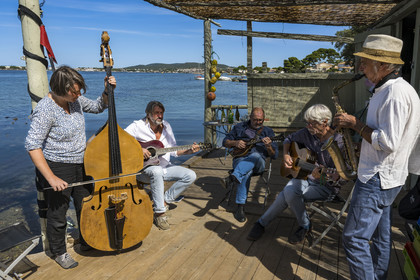 France, Hérault (34), Sète,  Pointe du Barrou sur les rives de l'étang de Thau, le groupe de musique Au Bois de mon cœur qui réinterprète les chansons de Georges Brassens, il est mené par le pêcheur sétois Jean-Louis Lambert au chant et à la guitare, Georges Cabaret à la guitare solo, Guy Blanc dit Guet au saxo alto, Denis Benito à la mandoline bluegrass et Tatiana à la contrebasse