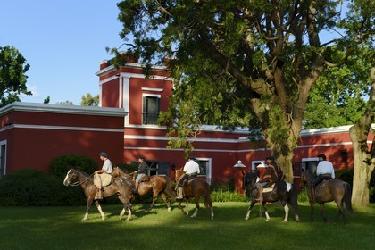 Argentine, province de Buenos Aires, San Antonio de Areco, groupe de gauchos à cheval devant l'estancia La Bamba de Areco