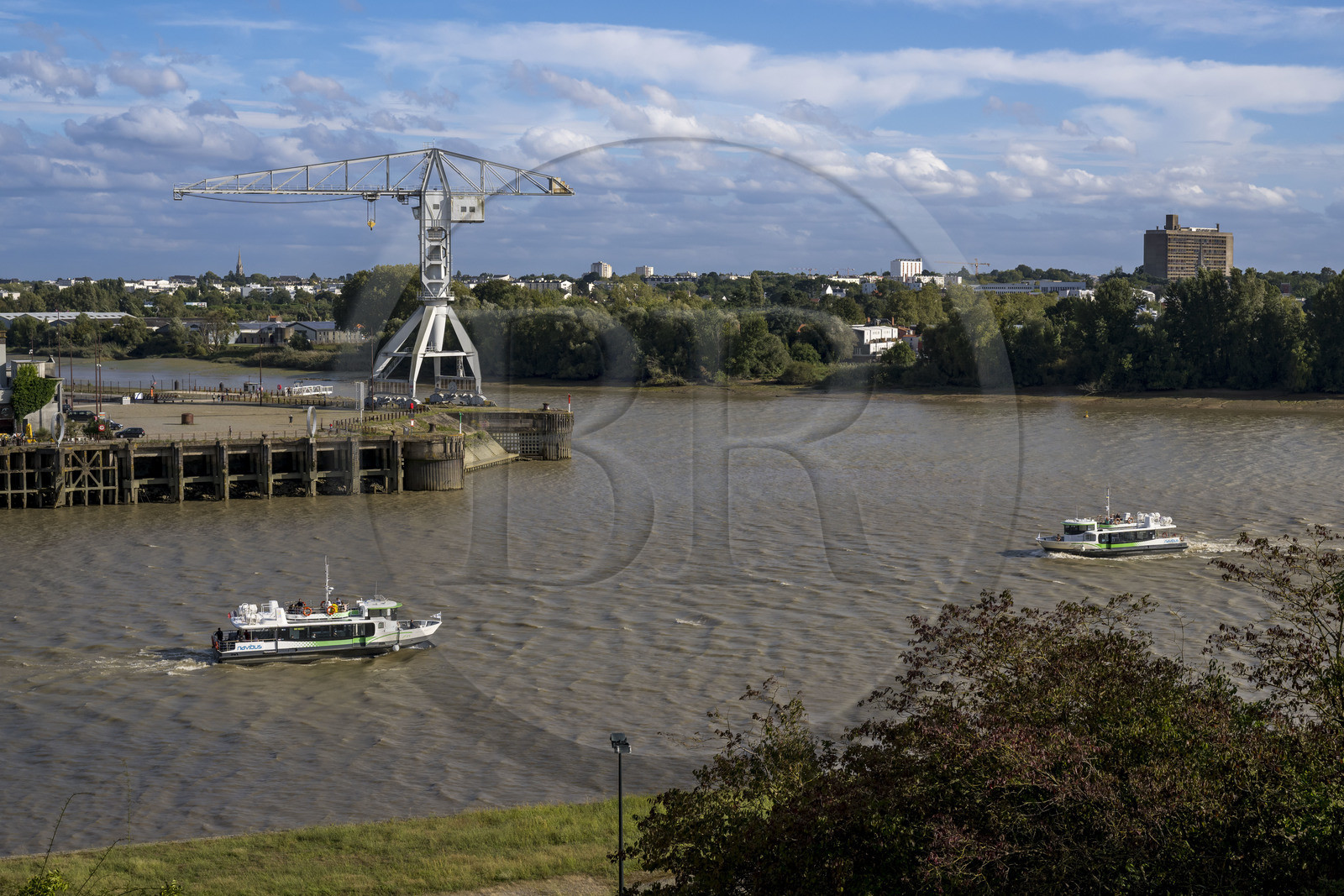 France, Loire Atlantique, Nantes, Ile de Nantes, the Navibus passing in front of the Banana Hangar on the banks of the Loire, the gray Titan Crane and Le Corbusier's Maison Radieuse in the background, seen from the heights of Chantenay