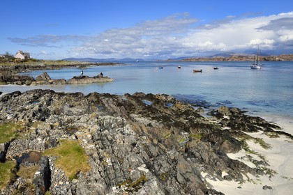 United Kingdom, Scotland, Highland, Inner Hebrides, rocks and sandy beach on Iona Island facing the Ross of Mull