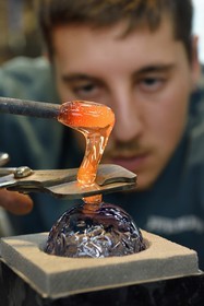 France, Moselle (57), Meisenthal, Centre international d’Art verrier (CIAV), l'atelier de soufflage, fabrication artisanale d'une boule de Noël, pose de la pastille pour la création du crochet en verre