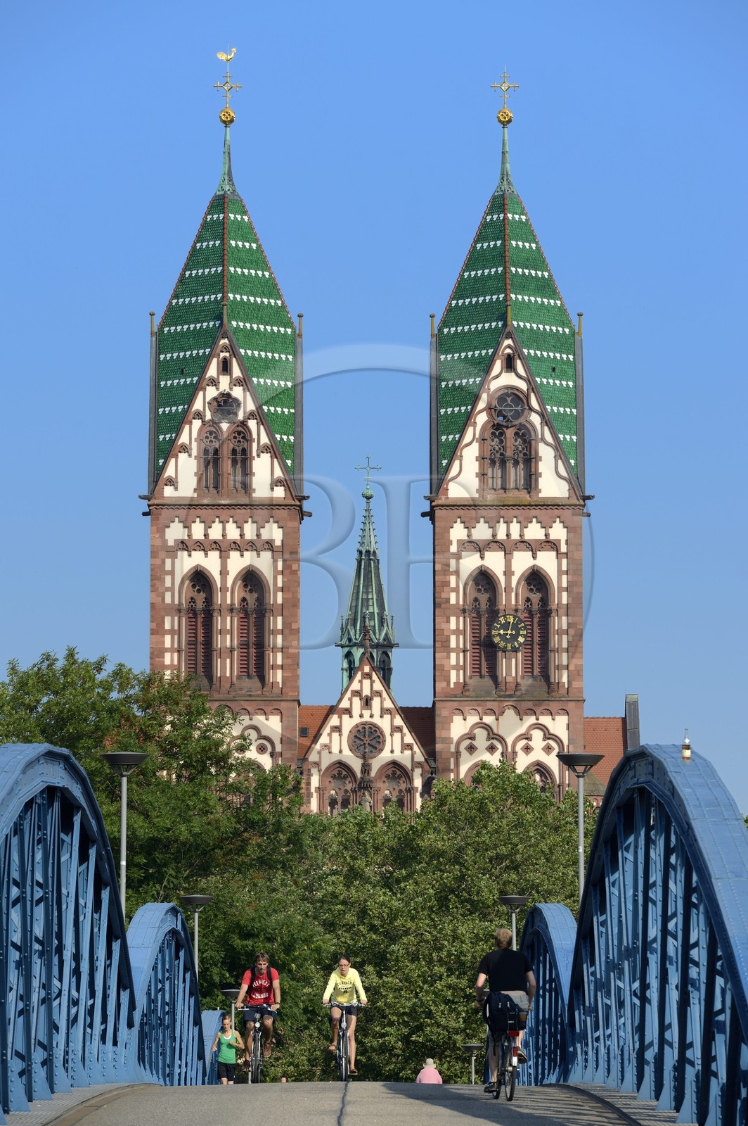 Germany, Baden-Wurttemberg, Freiburg im Breisgau, cyclist on the blue bridge (wiwili-bridge) and the Sacred Heart of Jesus Church (Herz-Jesu-kirche) in the background