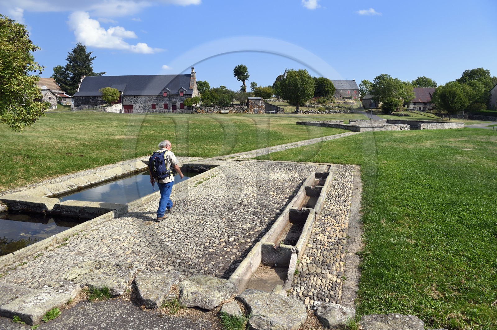 France, Cantal, Parc Naturel Régional des Volcans d'Auvergne (regional nature park of Auvergne volcanoes), step on the Way of St. James to Santiago de Compostela by Via Arverna, Chalinargues, common washhouse and drinking trough in the communal pasture