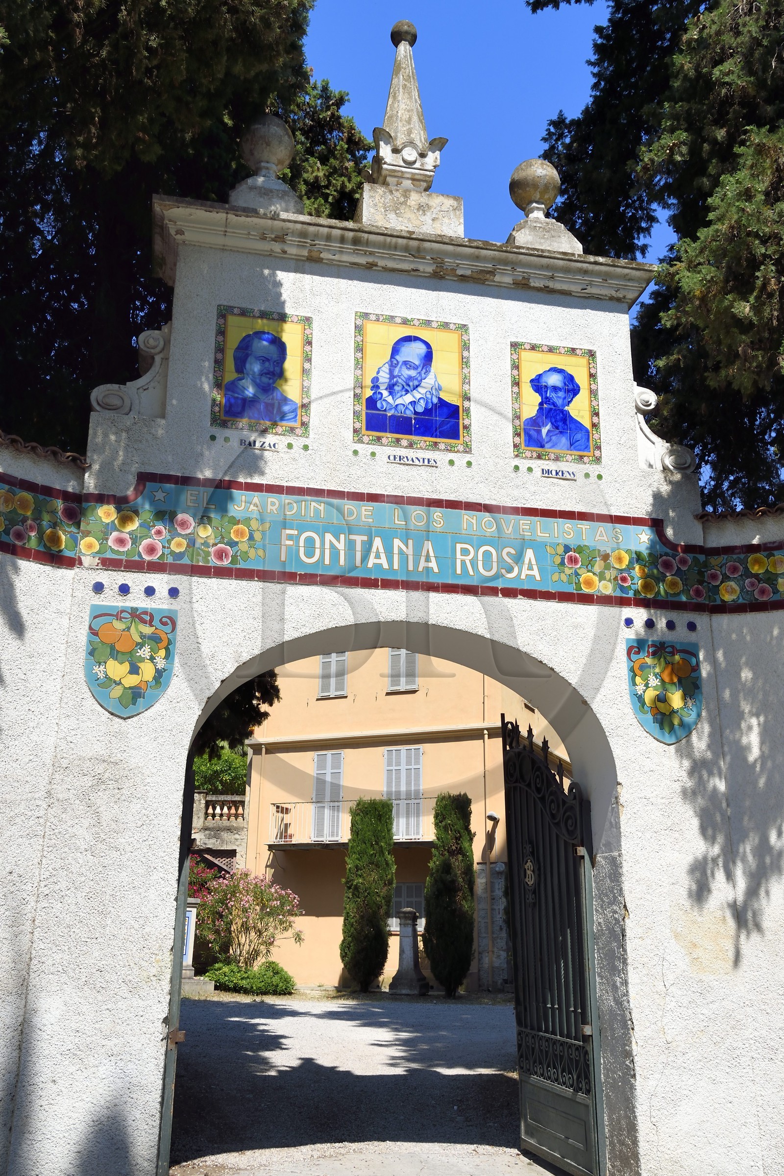 France, Alpes-Maritimes (06), Menton, Jardin Fontana Rosa, portail surmonté d’un fronton mouluré rectangulaire sur lequel se détachent les portraits en céramique de Balzac et de Dickens entourant celui de Cervantes