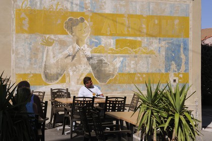 France, Var (83), presqu'île de Giens, terrasse de café sous une peinture murale publicitaire à Giens