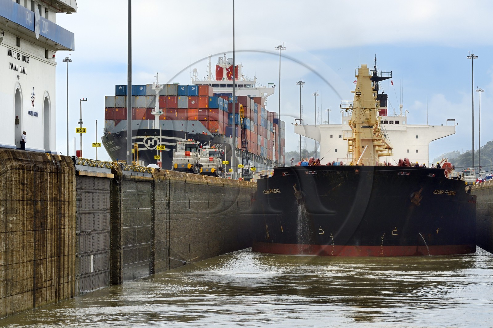 Panama, Panama Canal, Miraflores locks, mechanical mules or electric locomotives guiding a Panamax cargo between the lock walls
