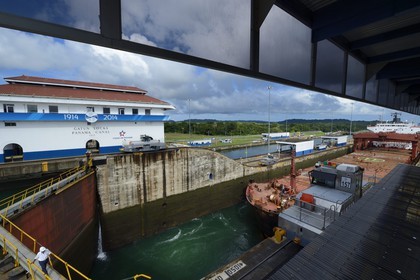Panama, province de Colon, Canal de Panama, écluses de Gatun, mules mécaniques ou locomotives électriques guidant un cargo Panamax entre les murs de l'écluse