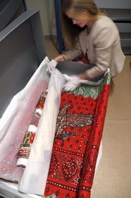 France, Alpes de Haute Provence, Ubaye valley, Barcelonnette, mexican villa known as Villa Sapiniere, Valley Museum, the curator Helene Homps in the museum reserve observes a embroidered dress called China poblana, Mexican national costume worn by the wives of Barcelonnettes for July 14 in Mexico