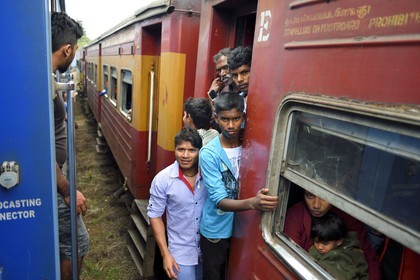Sri Lanka, Central Province, the popular scenic train ride through the tea growing hill country between Hatton and Badulla, Great Western train station, passengers hanging on the door