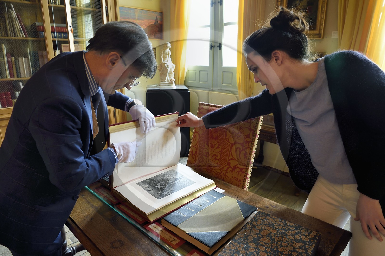 France, Aisne (02), Château-Thierry, Musée Jean de La Fontaine - Ville de Chateau-Thierry, le directeur du pole muséal Nicolas Rousseau et sa directrice adjointe Marie-Mileva Pavlovitch observant le livre des Fables de La Fontaine, édition illustrée (1867, in-folio) par Gustave Doré