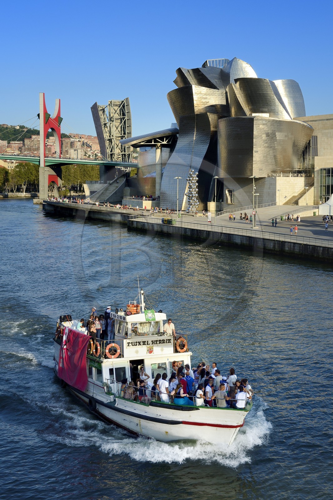 Spain, Basque Country Region, Vizcaya Province, Bilbao, the Guggenheim Museum designed by Frank Gehry and the Salve bridge with Les Arches Rouges artpiece by French artist Daniel Buren in the background