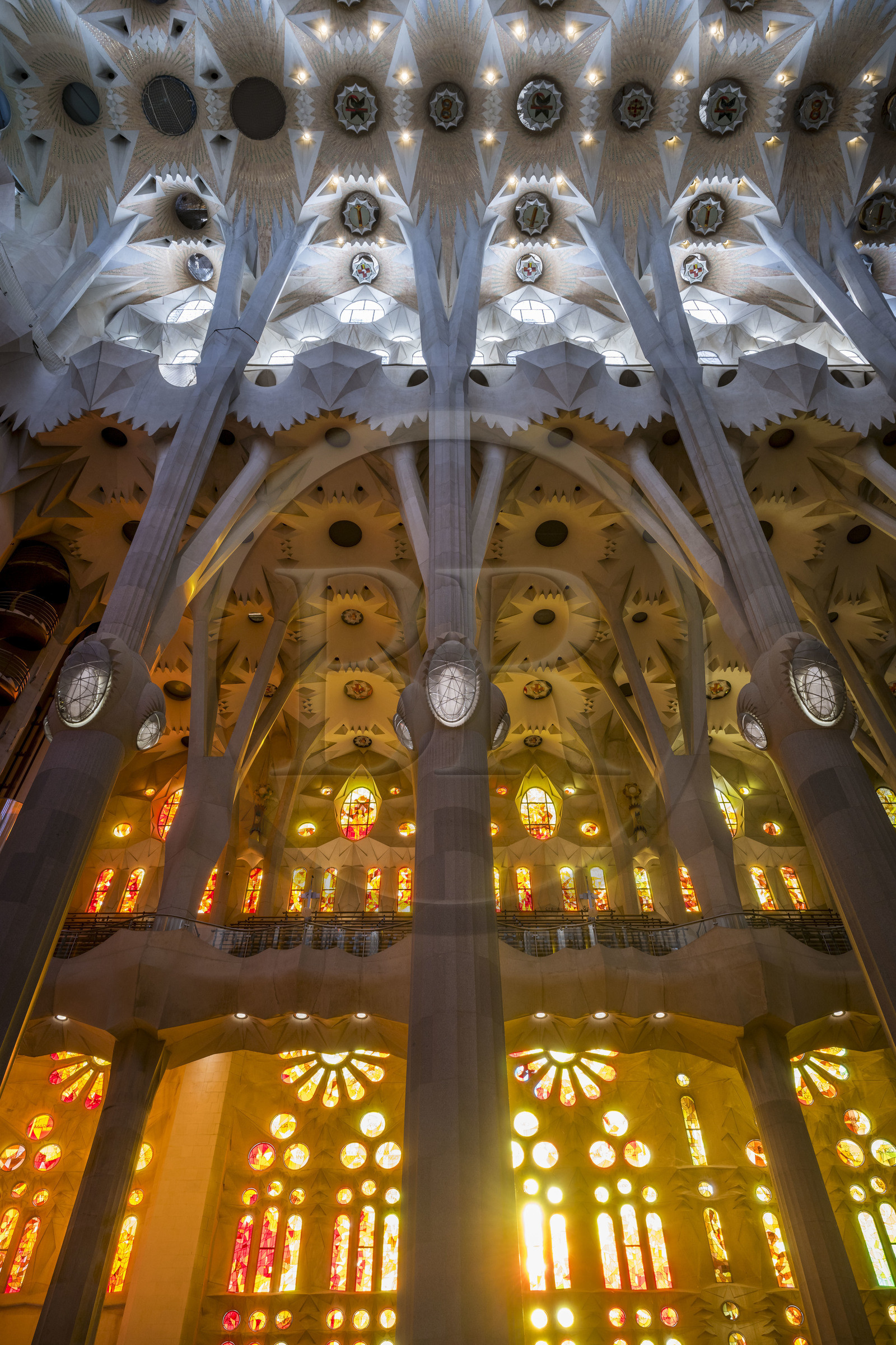 Spain, Catalonia, Barcelona, Eixample district, Sagrada Familia basilica by Catalan modernist architect Antoni Gaudi, listed as a UNESCO World Heritage Site, the facade side of the Passion of the Nave with its warm-colored stained glass windows and the vault at the top