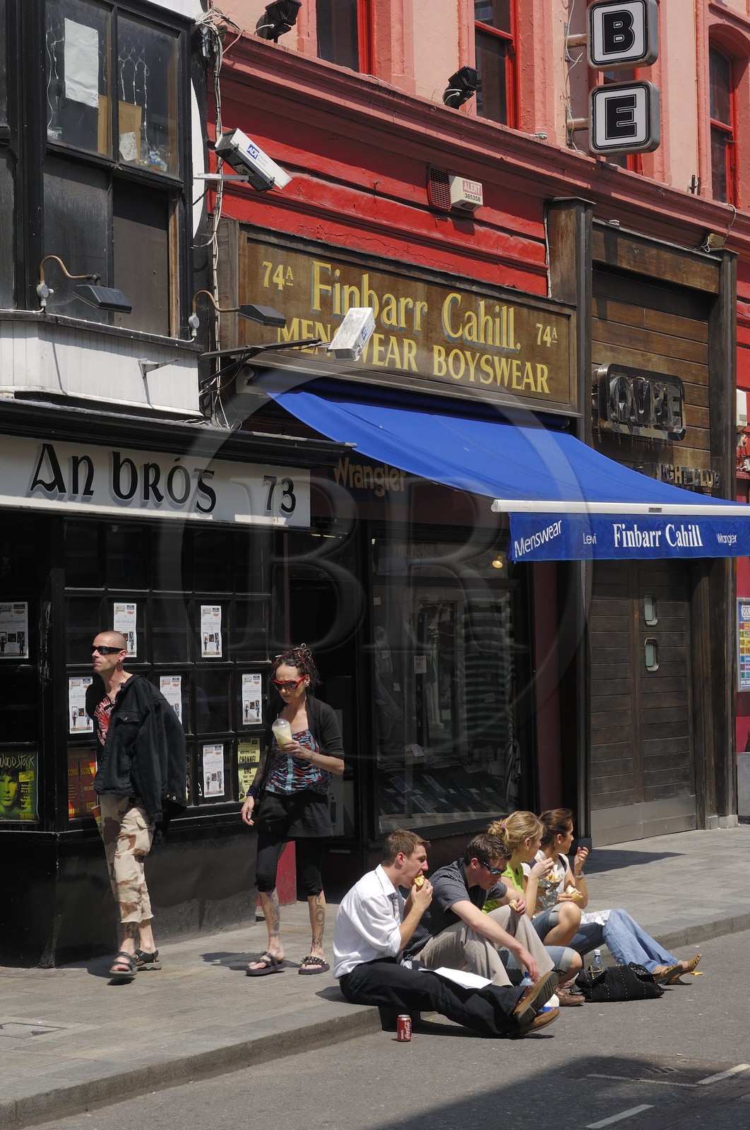 Irlande, Comté de Cork, Cork, groupe assis sur un trottoir