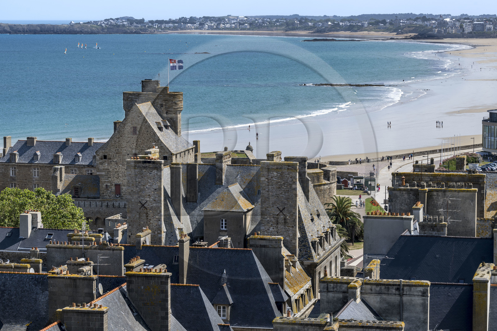 France, Ille et Vilaine, Cote d'Emeraude (Emerald Coast), Saint Malo, the roofs of the inner city, the Grand Donjon on which the city flag flies and the large Sillon Beach in the background