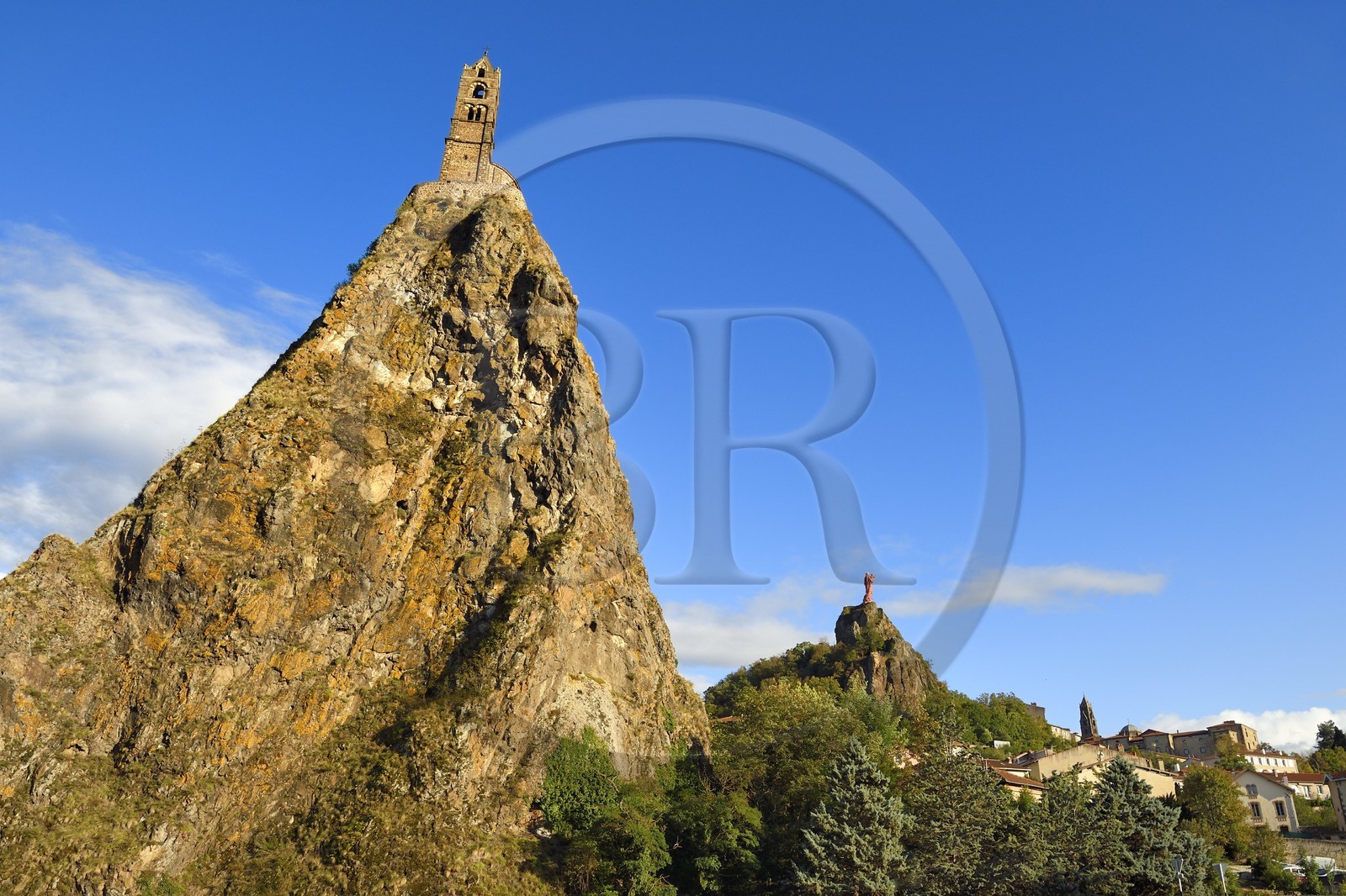 France, Haute Loire, Le Puy en Velay, Routes of Santiago de Compostela in France listed as World heritage by UNESCO, view of the city with the Saint-Michel d'Aiguilhe Chapel perched on a volcanic peak in the foreground, the Notre Dame de France statue (from 1860) on the Rocher Corneille overlooking the 12th century Notre Dame de l'Annonnement cathedral in the background