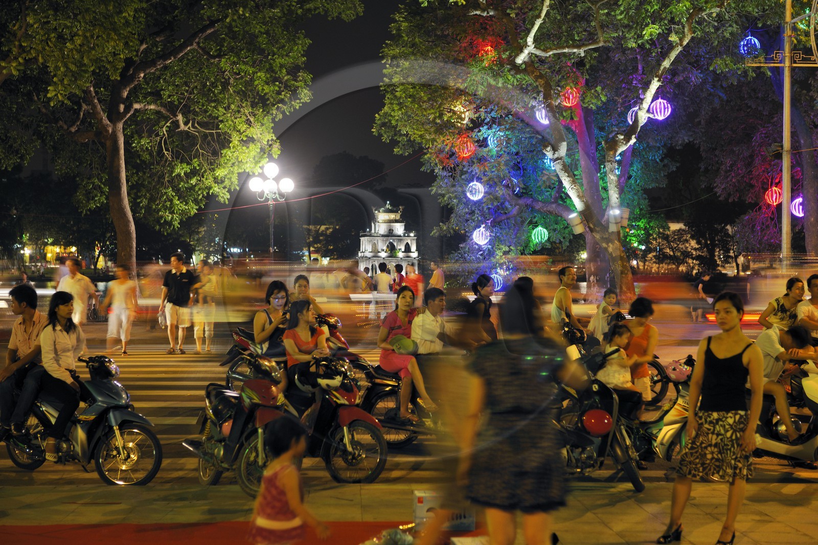 Vietnam, Hanoi, old town, the Turtle tower (Thap Rua) on Hoan Kiem Lake also called the small lake or Lake of the Restored Sword, going out on saturday night on motorbike