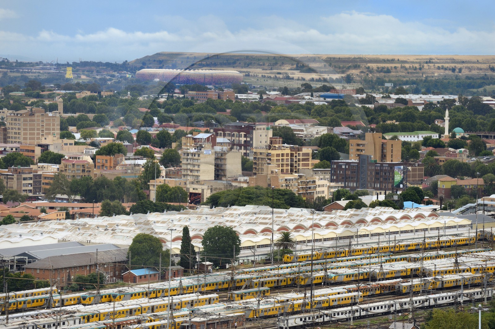 Afrique du Sud, province de Gauteng, Johannesburg, les wagons de trains colorés de Park Station et le Soccer City Stadium à Soweto au pied d'un immense terril d'une mine d'or en arrière plan