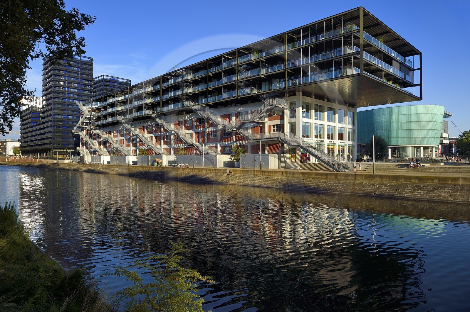 France, Bas Rhin, Strasbourg, development of port du Rhin (Rhine's harbour) and conversion of breakwater of Bassin d'Austerlitz, presqu'ile Malraux (Malraux peninsula), former Mole Seegmuller warehouse turned into commerce and residential flats on the edge of the Austerlitz basin, the buildings the Black Swans in the background