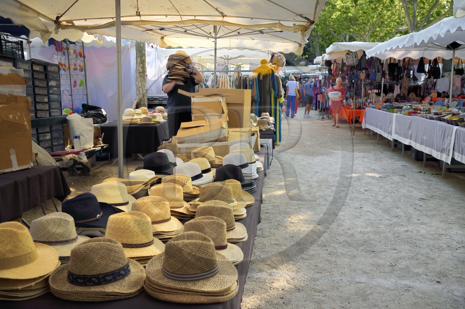 France, Var (83), Saint-Tropez, place des Lices, terrasse de cafés et étals de produits artisanaux à l'occasion du marché hebdomadaire le samedi matin, étal de chapelier