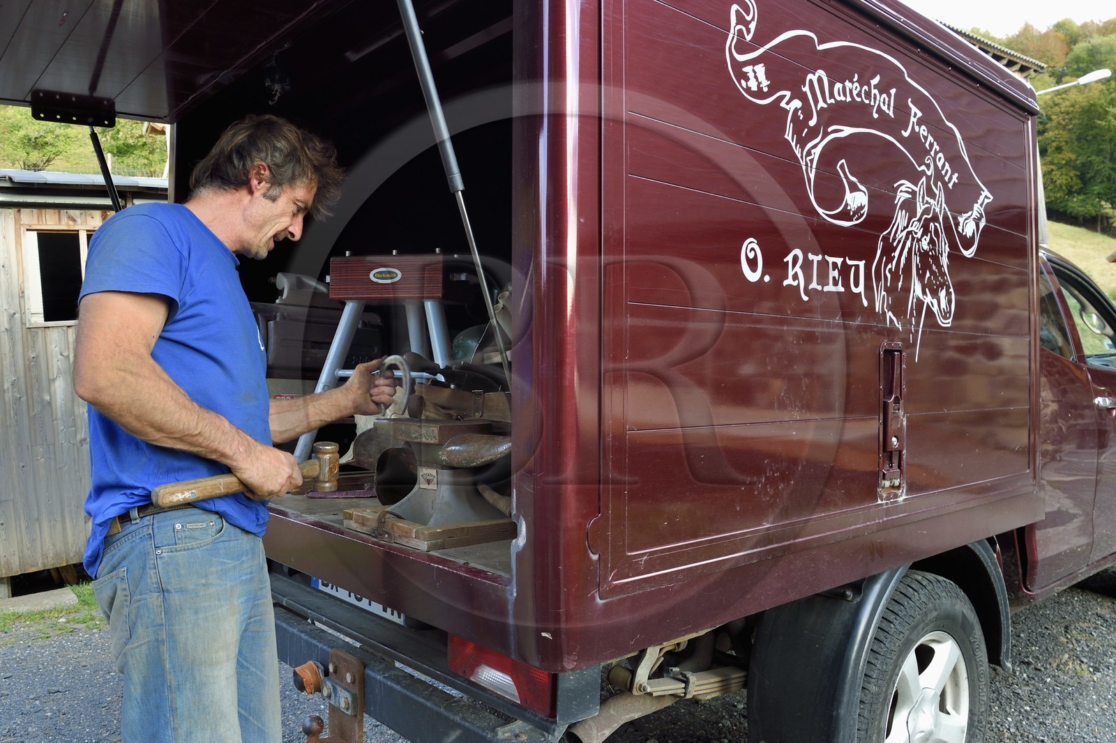 France, Ardèche (07), parc naturel régional des Monts d'Ardèche, massif du Mézenc, Lac-d'Issarlès, Ferme de La Louvèche, le maréchal Ferrant Olivier Rieu travaille un fer à cheval dans son atelier itinérant